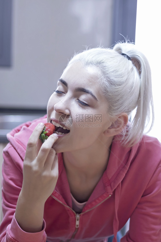 可爱的女人吃草莓紧贴女脸部肖像健康饮食盘子手图片