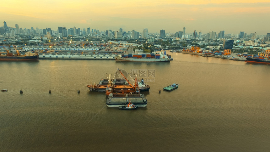 天线血管由Klongtuey港口和集装箱船在Chaopraraya河中心Bangkokthailand首府上空装载稻田的水角度图片