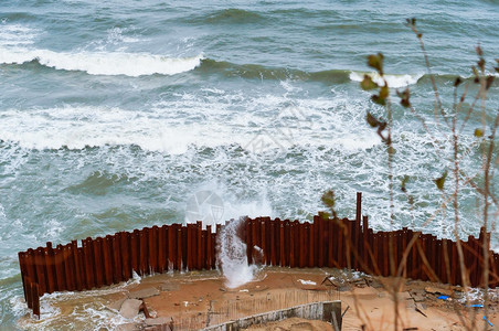 水加里宁格勒海浪围绕着栅栏大海和风暴浪围绕着栅栏打破石头图片