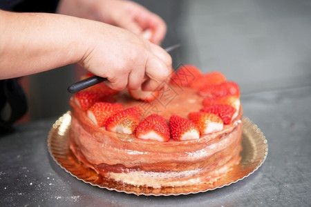 烹饪餐厅糕点师在店厨房制作美味的草莓蛋糕点师制作美味的草莓蛋糕一种图片