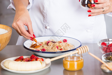 制作人们浆果烹饪准备用酸奶水果和谷物做的甜点图片