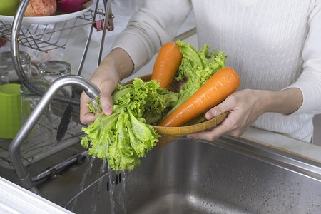 透过厨房妇女手洗有机生菜和胡萝卜蔬的窗框浏览在厨房里液体食物有机的图片