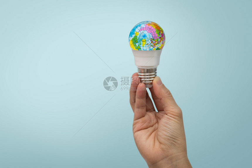 手握着LED灯泡蓝底环球时髦的商业发光图片