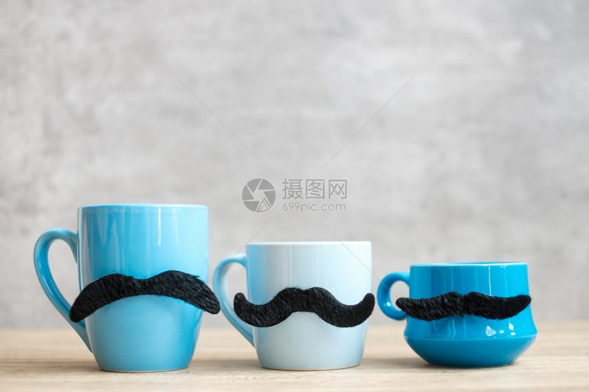 国际的行进蓝咖啡杯和茶在1月蓝色清晨父亲节和国际男子概念中用黑胡子装饰画在木桌背景上九月图片