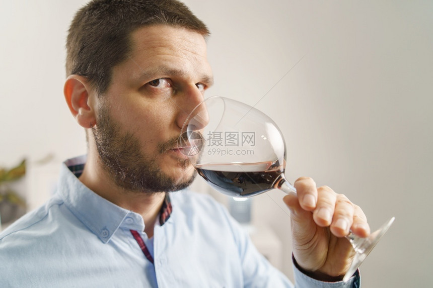 成年黑人男子穿着盛红酒杯的衬衫晚上或在家喝葡萄酒身着大胡子和短头发的男在家中紧闭抓住成人满意图片