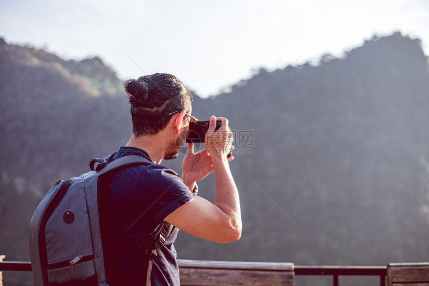 亚洲男子背包和旅行者一起走在欢乐地山上拍照假期概念旅行时间较慢快乐的朋友们谊图片