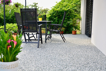 绿色后院带有装饰自然石地板花盆和有椅子的桌美丽双层锅图片