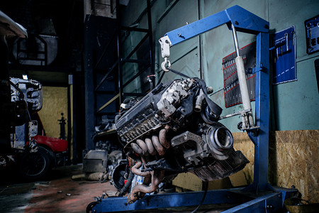 汽车修理服务蓝色起重钩上的发动机通气生产起重器图片