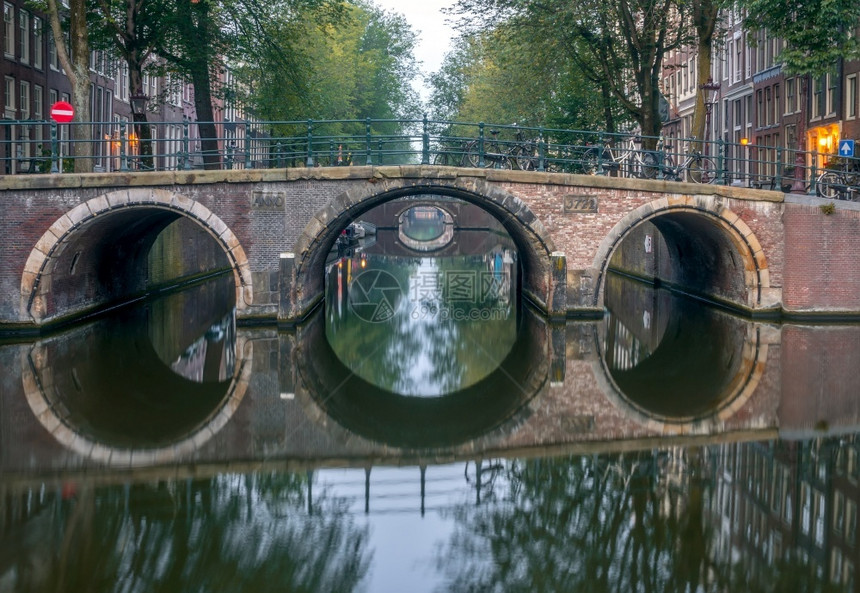 住宅荷兰上午关于阿姆斯特丹运河的天气和一系列具有反射力的桥梁阿姆斯特丹清晨桥在寒冷的天气中人们荷兰语图片