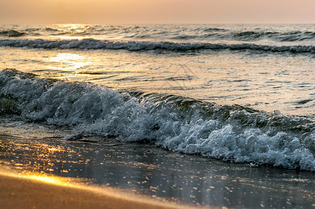 黎明海上日落阳光下的海浪红色海浪上的日落场景岸线图片