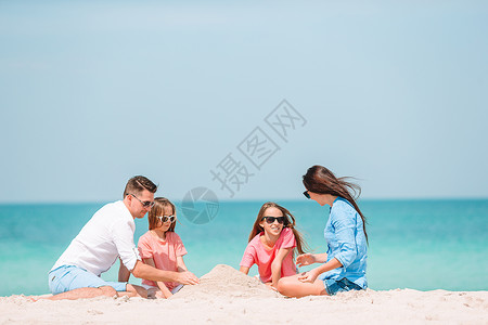 童年家庭在热带海滩制作沙堡一家四口在热带白色海滩制作沙堡滨闲暇图片