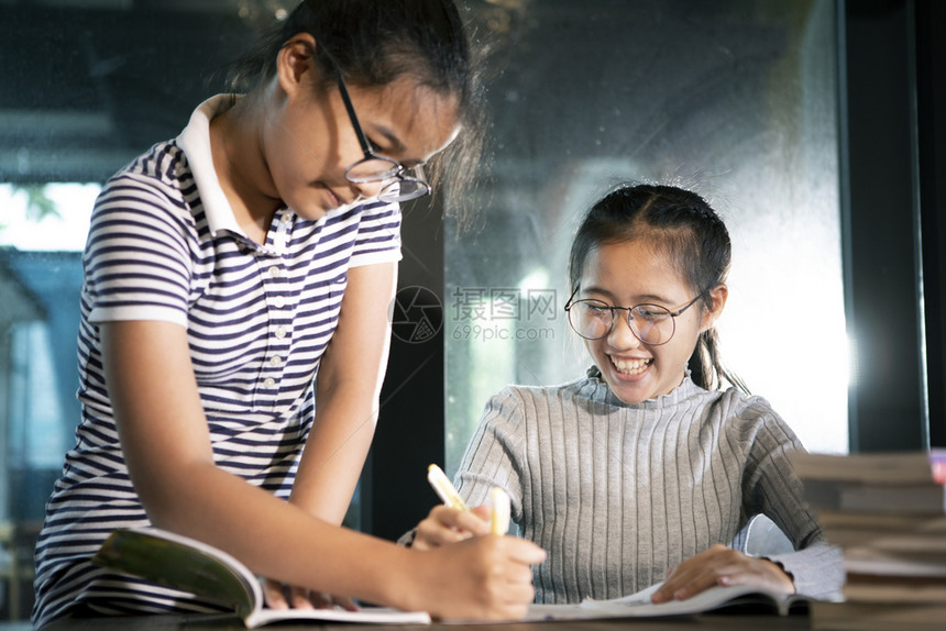 女孩子们两个亚裔学生读一本充满幸福感的书乐趣图片
