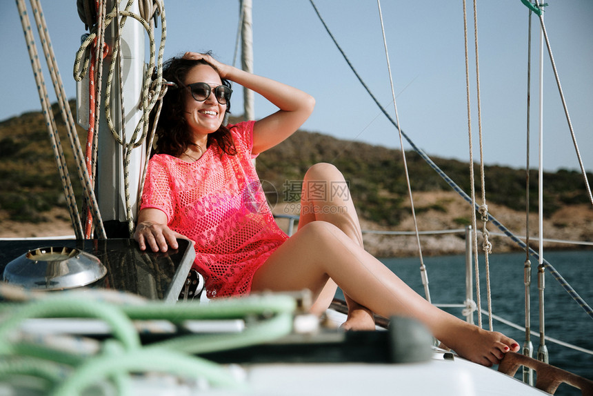 束腰外衣坐在帆船上的穿着外衣年轻和感女人在海上游轮中享受暑假风快乐的图片