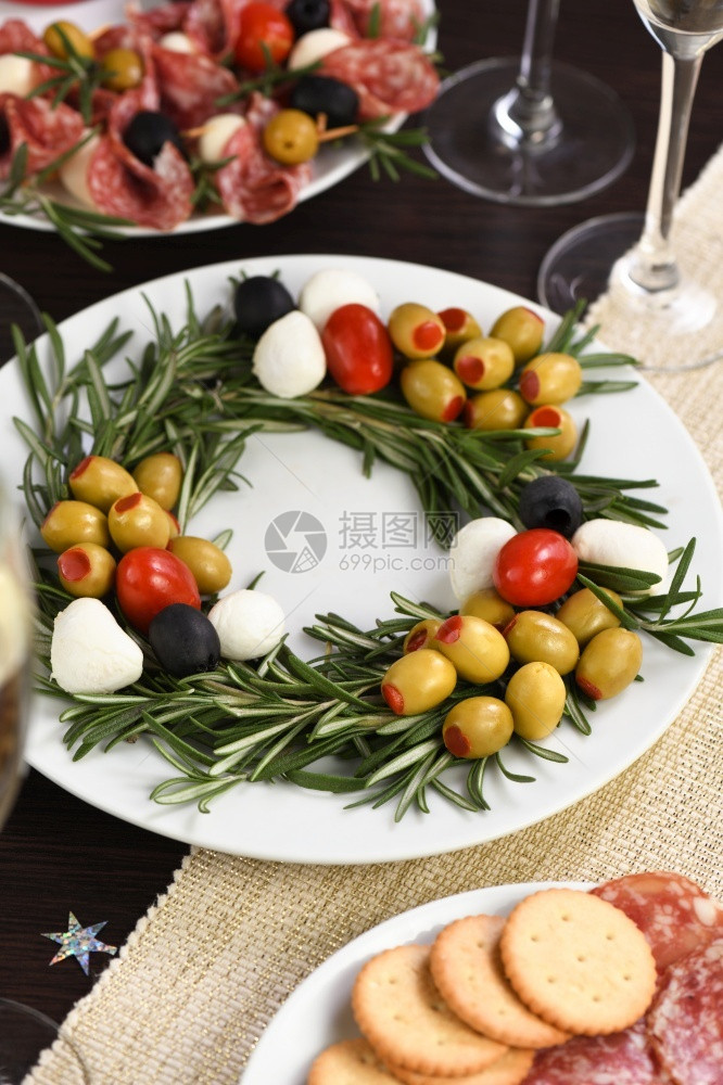 开胃菜自助餐以圣诞花圈形式制作的盛开胃迷迭香配满橄榄和小奶油辣椒樱桃番茄健康图片