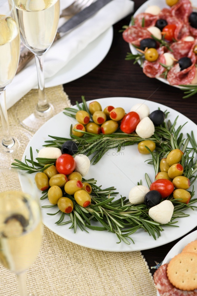 庆祝的塞满以圣诞花圈形式制作的盛开胃迷迭香配满橄榄和小奶油辣椒樱桃番茄滋养图片