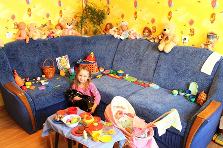 小女孩在她房间里玩具和猫咪沙发动物白色的图片
