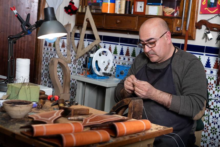 创建在他的小型车间里做皮革的工匠细节鞋图片