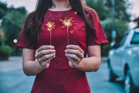 海滩手举办圣诞节和新年庆祝活动的有烟火妇女假期图片