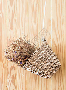 稻草竹篮中的干花束挂在木墙上产品艺术图片