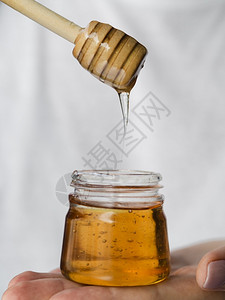 杓Olympus数字摄影机的蜂蜜从顶端滴落食物糖浆图片