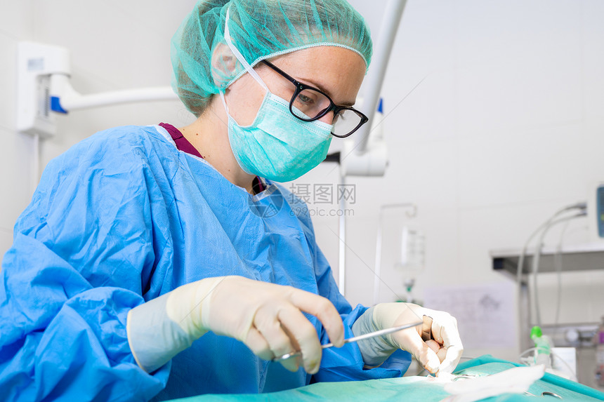 女医生穿着无菌服在手术室进行手术图片