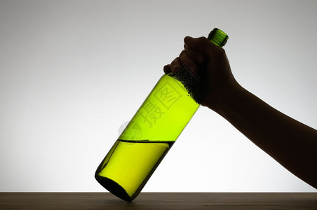 捕捉半透明握着一个绿色酒瓶的手摇轮饮料图片
