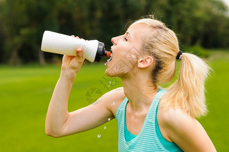 公园里喝水的女人图片