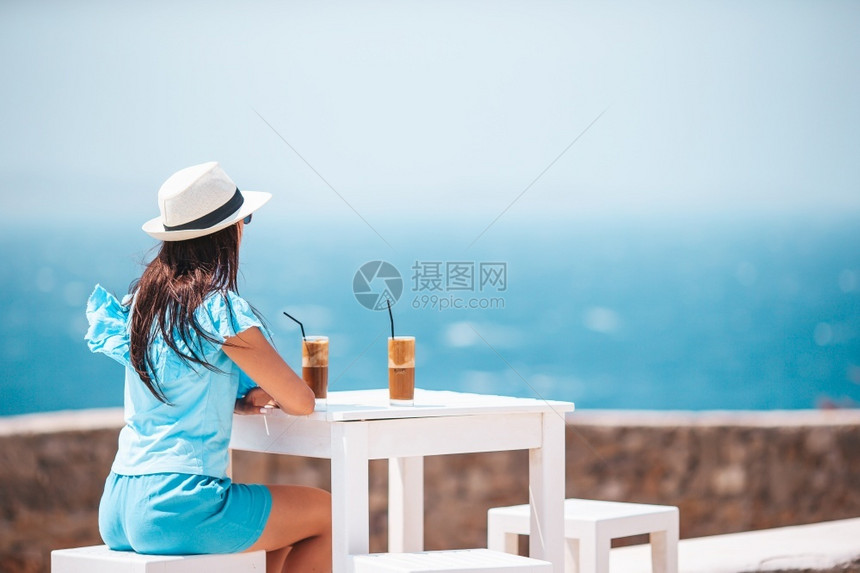 海洋女士在户外咖啡厅喝冷享受海景的年轻女子喝冷咖啡享受海景的年轻女子外部图片