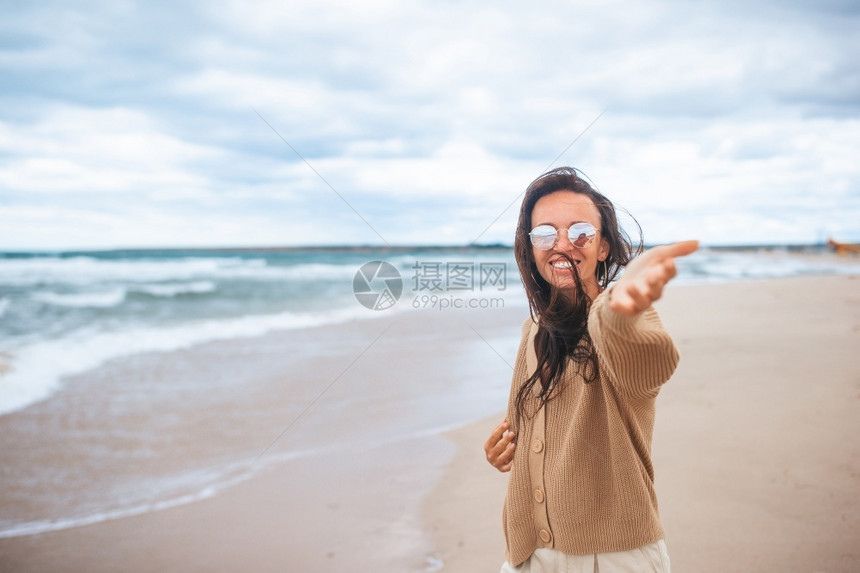 奢华目的地松弛年轻快乐的女子在海滩度假年轻快乐的女子在海滩度假图片