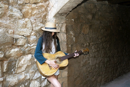 女青年音乐家穿暑期服装弹声吉他户外常设夏天图片