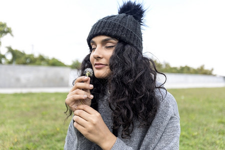 白种人华丽的美黑发女闻着花朵的黑头发女人气味一种图片