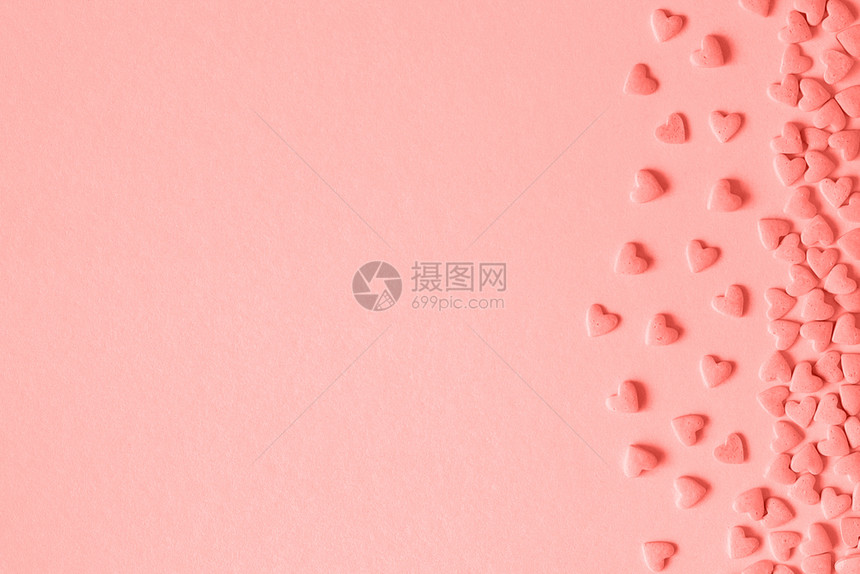 蛋糕心形糖果洒在珊瑚色调的粉红背景右侧用于贺卡文本设计复制空间的模板心形糖果洒在珊瑚色调的粉红背景右侧用于贺卡复制空间的模板装饰图片