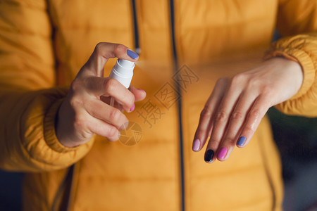女孩用喷雾给手消毒图片