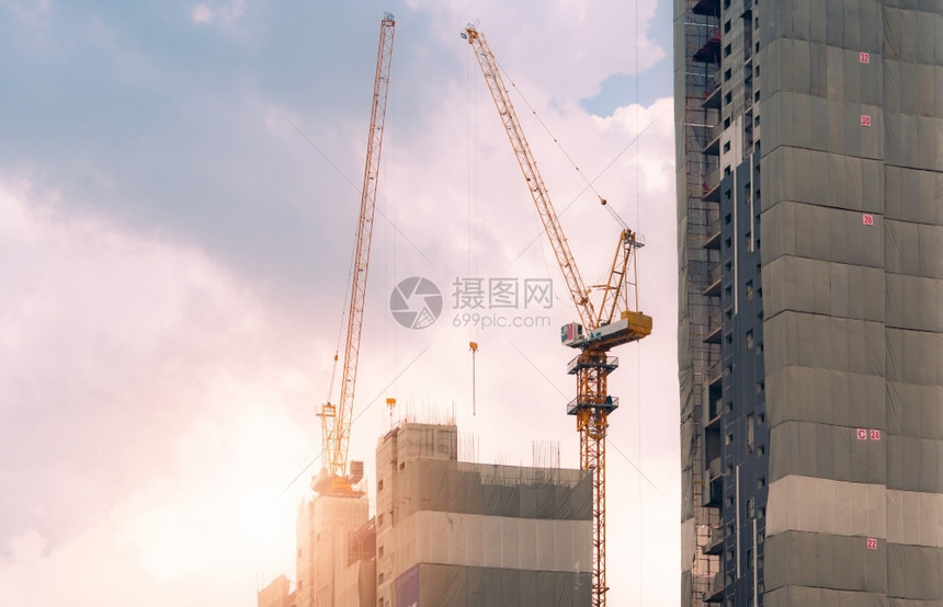 行业Crane在建筑工地上使用雷el提升设备公寓楼建筑工地造起重机对天工程建造起重机与天空对面工作建造起重机商业的工程师图片