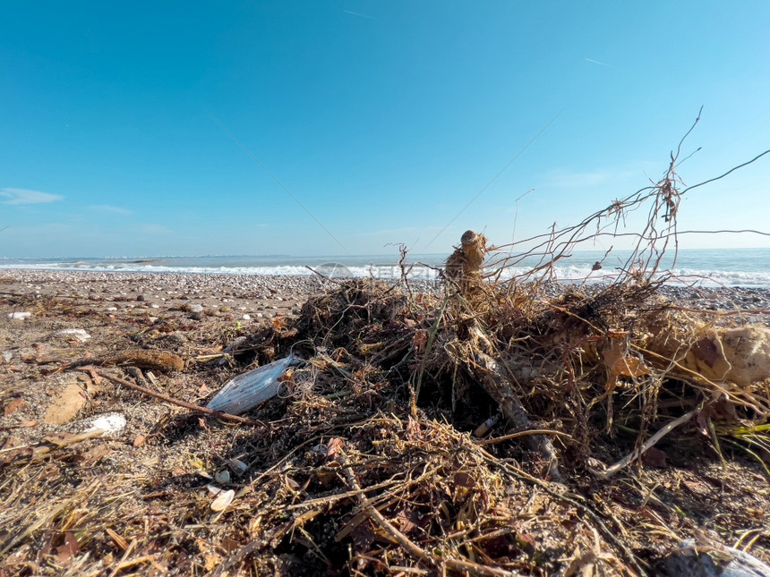 浪费大城市海滩上的垃圾空无所用脏塑料瓶子肮的海沙岸环境污染生态问题水灾难倾倒图片