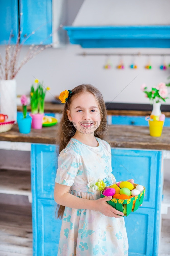 可爱的女孩拿着篮子和彩蛋在厨房煮饭为假日复活节可爱女孩做饭带彩蛋的篮子颜色绿烹饪图片