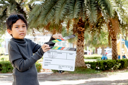 男孩左手指引演戏亚洲男孩为电影和视业持有影板色的和视业片目快板背景