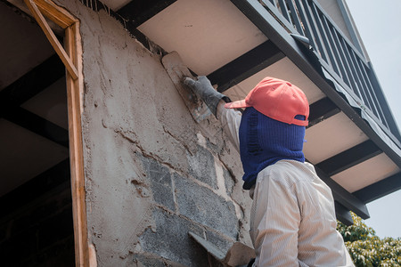 家建筑工人使用水泥石膏在建筑墙上打石膏画家磨图片