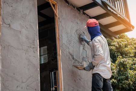 工作服建筑人使用水泥石膏在建筑墙上打石膏设者真实的图片