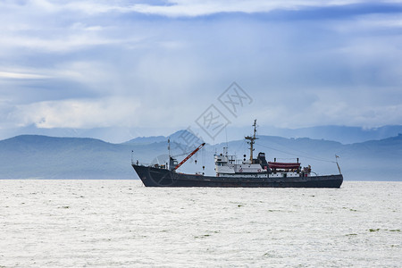 丘陵港口金属三艘大型渔船在山丘和火背景上航行3艘大型渔船图片