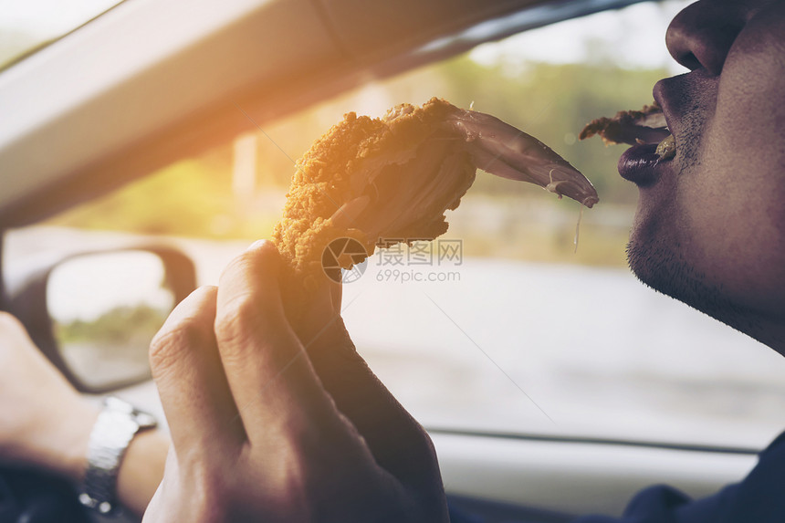 车内吃炸鸡的男子图片