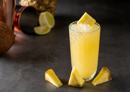 酒吧石背景中带菠萝椰子和柠檬的鸡尾酒果汁薄荷图片