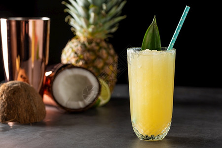 水果绿色石背景中带菠萝椰子和柠檬的鸡尾酒白色图片