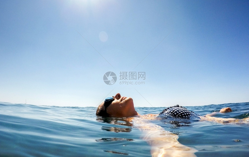 妇女漂浮在水暑假上年轻的床垫戒指图片