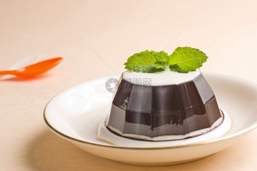 甜美奶油碟子白陶瓷餐桌上的咖啡布丁甜点图片