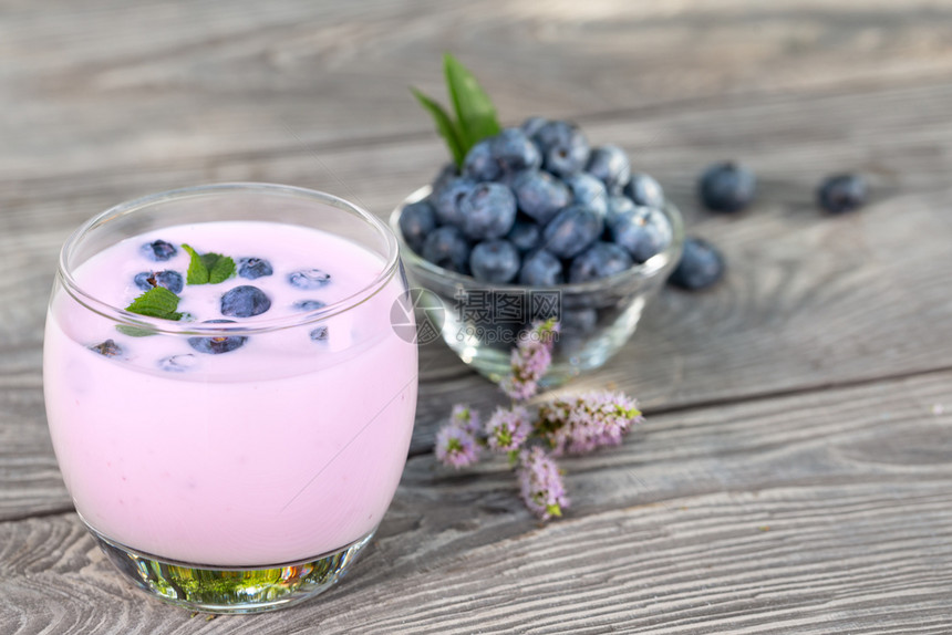 在木制桌边的薄荷在玻璃和桌子上脱毒贝里香水或酸奶和蓝莓在木制桌边的碗里脱毒贝冰雪或酸奶和蓝莓在木制餐桌上的概念饮料健康甜点图片