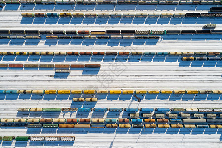 雪冬季平行铁路轨道上许多彩色货运列车的顶层空中景象工业概念A车站天线图片