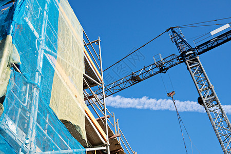过程利用蓝色天空建筑工地正在造的筑物上Crane和脚手架基础框图片