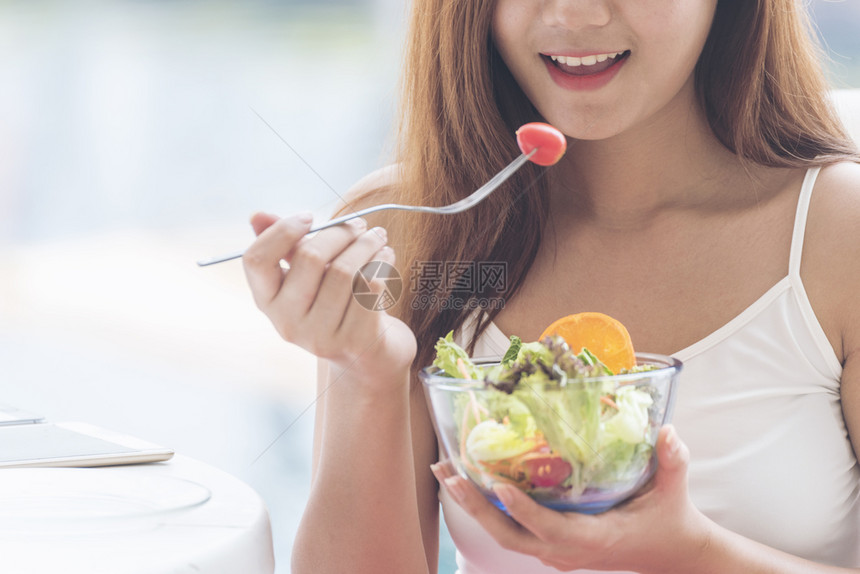 自然漂亮的健康食品生活方式年轻快乐的女青吃绿色新鲜原料有机沙拉Vegan女孩拿着沙拉碗笑脸面吃健康饮食物格图片