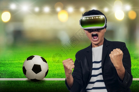 足球视频边框竞赛扇子幸福有耳头的年轻人乐于在足球比赛上欢呼背景模糊年轻人用虚拟现实耳机以虚拟现实耳机设计图片